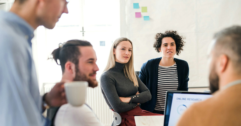 A representation of a group of colleagues in a meeting listening to somebody speaking