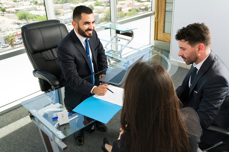 Models display an office scene, where a confident AI consultant outlines a plan for his bosses.