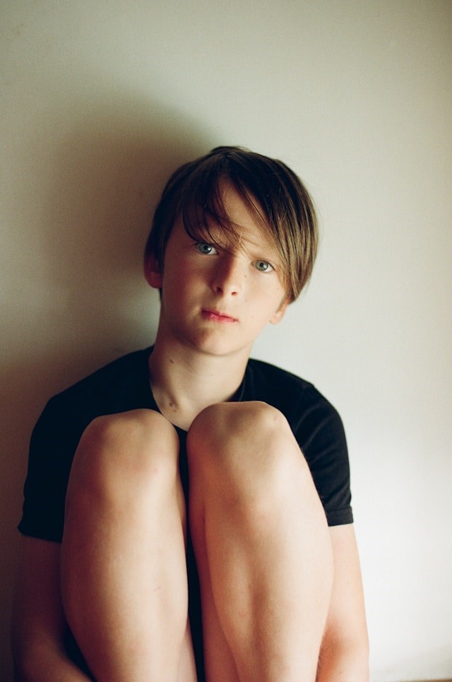 Child portrait featuring natural light and a minimalist background.