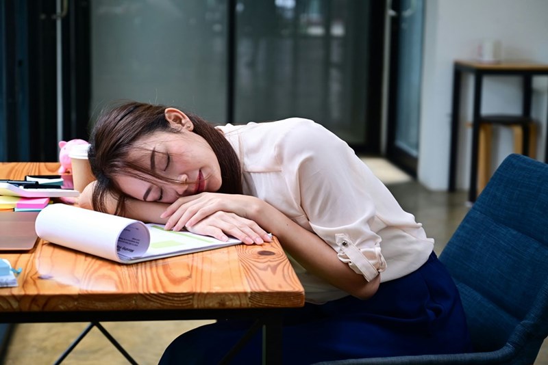 Depiction of an employee who has fallen asleep at work.