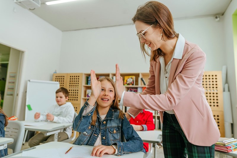 Teacher high-fives her 13-year-old client, as depicted by models.