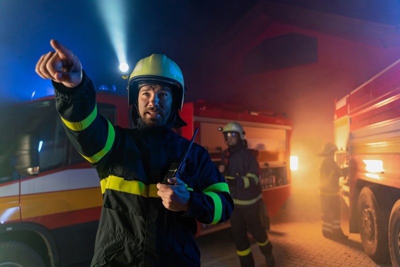 Firefighter commands his team, pointing out where to go, in a representation by a model.