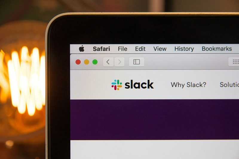 A photograph of a laptop open to the Slack app.