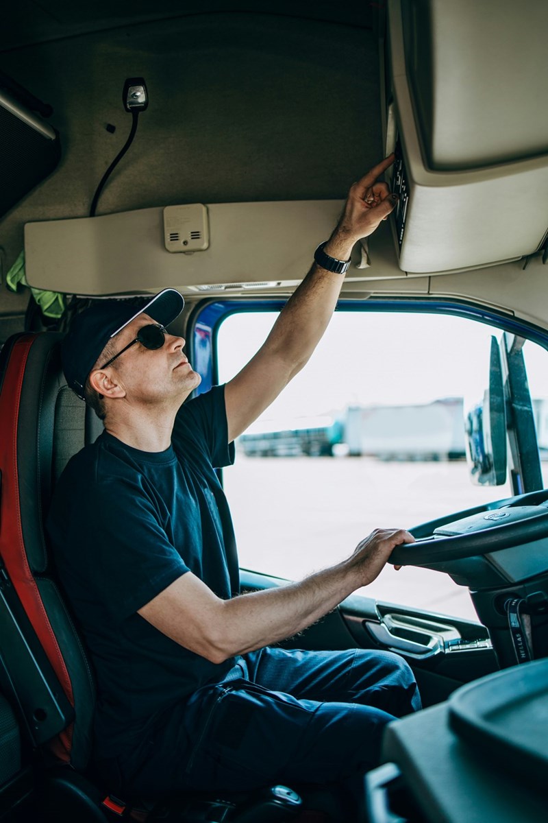 Truck driver examines his rig before beginning a long day on the roads, in a photo depiction from a model.