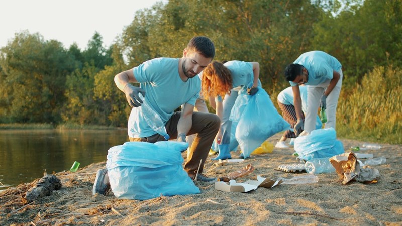 Teens work together to pick up trash in an outdoor setting, as demonstrated by models.