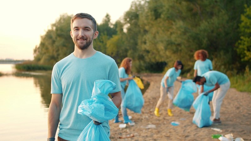 Teen walks away from his peers who are still picking up trash, as he leaves to get a coffee with his Mom, as shown in a depiction by models.