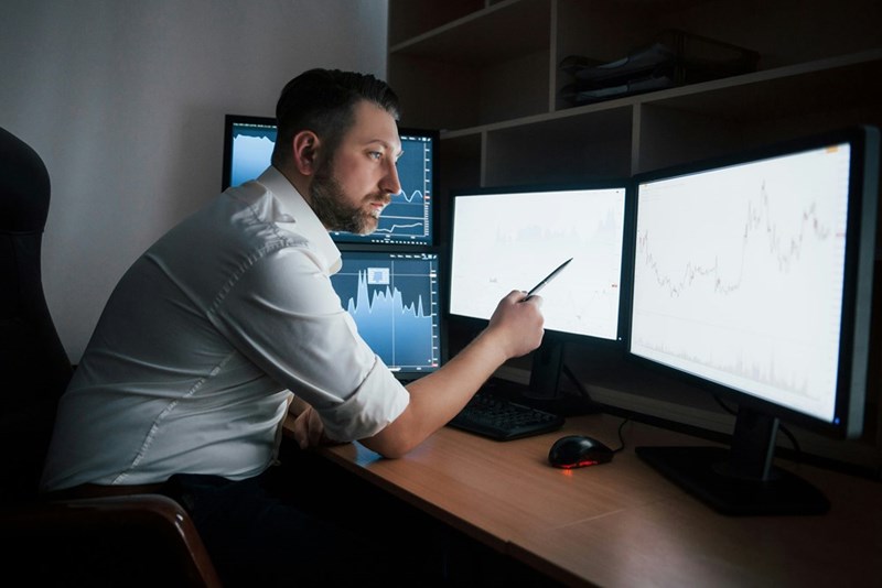 A photographic depiction of an engineer working on monitors.
