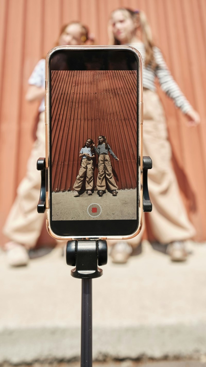 2 influencers set up a tripod to film while waiting to try a trendy food, in model's depiction.