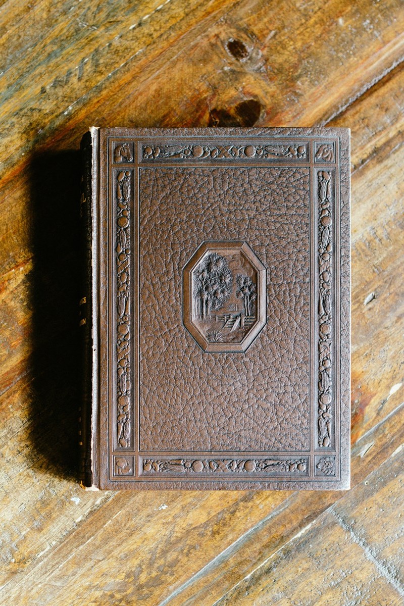 A photo of an ornate diary cover lying on a wooden table.