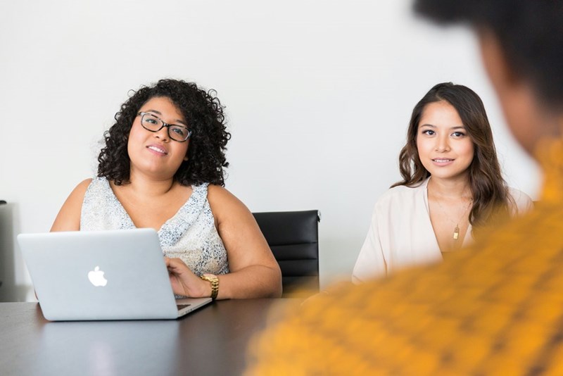 2 employees look dismayed after hearing that they won't be getting any monetary bonuses for their work, in a representation by models.