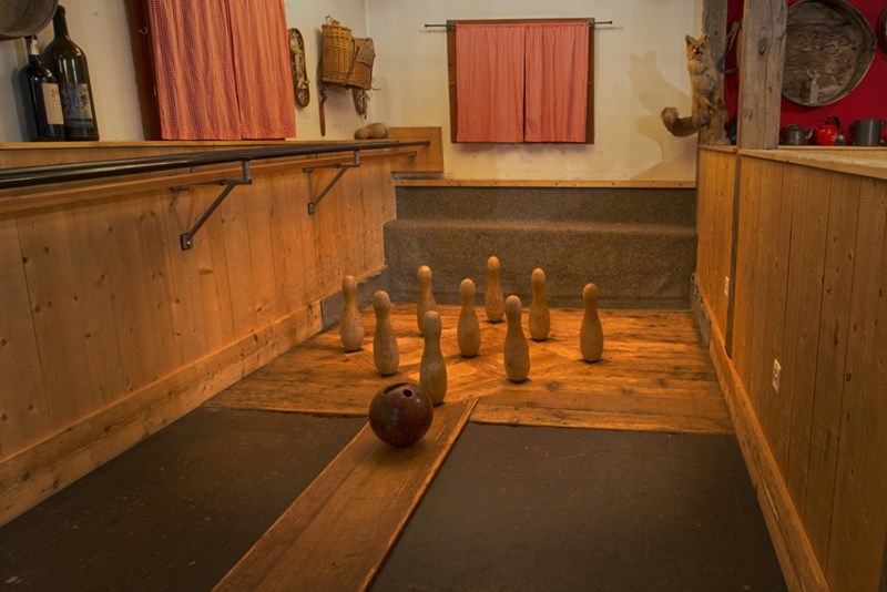 A representation of a home bowling set inside an apartment, with a ball and pins prepared for a bowling game.