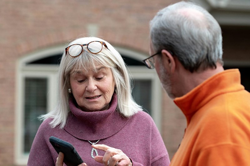 The homeowner explains to the neighbor that they've called the cops on them, in a representation by a couple of models.