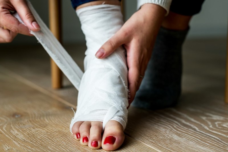Lily wraps her injured ankles, which hurt so badly that she cannot do her usual household chores, which, for some reason, include her roommates' laundry. 