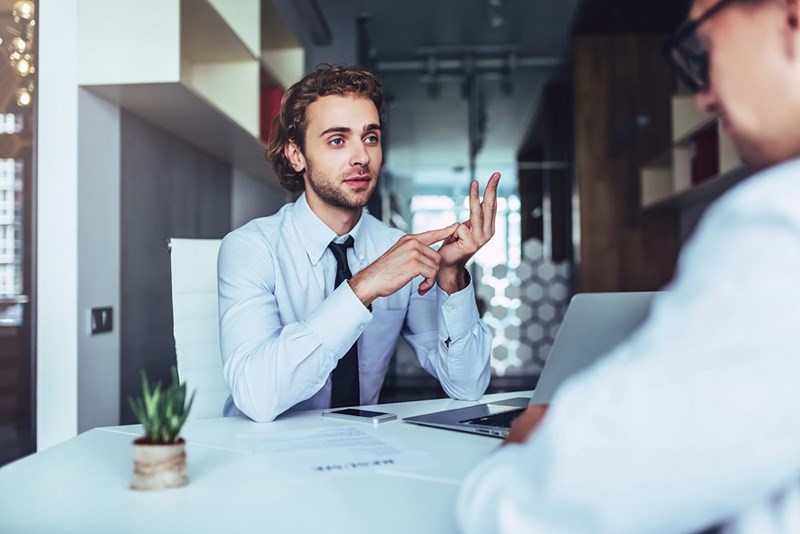 Job candidate lists out his concerns during an interview, as represented by a model.