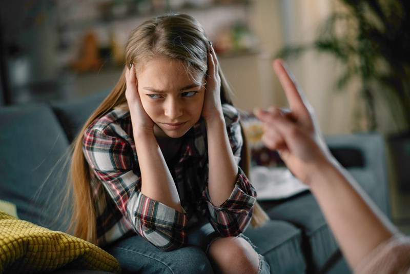 A representation of a mother scolding a teenage girl for getting a B in Social Studies, which only makes her rebel more by getting an F on a Geometry test. 
