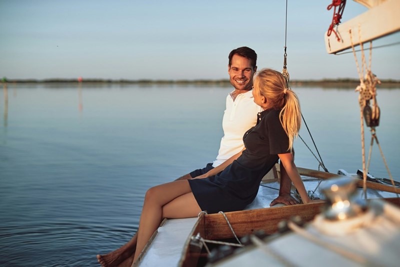Couple relaxes on the water, enjoying their new boat before discovering it's hidden flaws, in a representative photo by models.