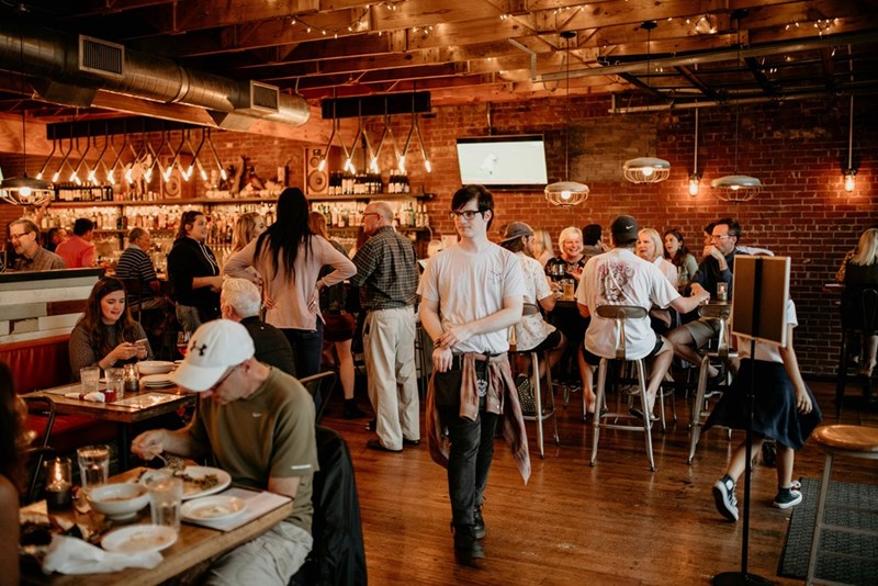 A crowded restaurant full of hungry diners, in a depiction by models.