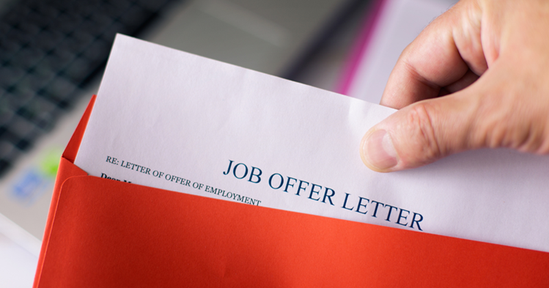 Person (model) holding a job offer letter.