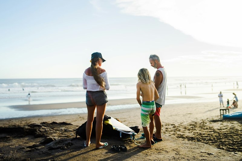 Family members spend quality time together on a beach vacation by the ocean.