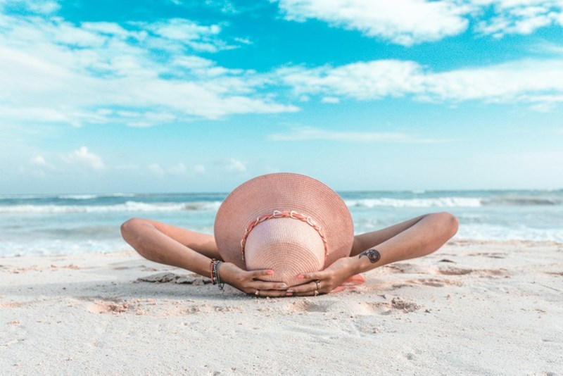 Solo traveler relaxes on a peaceful beach while enjoying a quiet moment away from everyday stress.