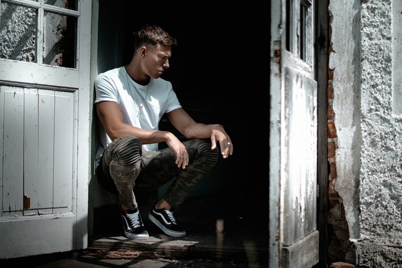 man sitting beside white door