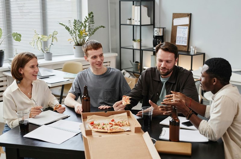 employees eating pizza together was bought by their coworker, who is leaving the company on Friday, and who was excluded from their boss's office lunch earlier that week.