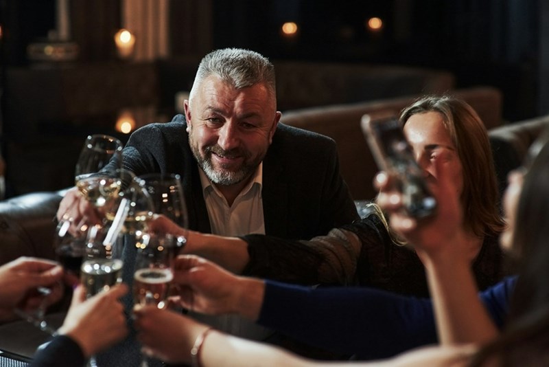 A group of people raise their glasses during a celebration.