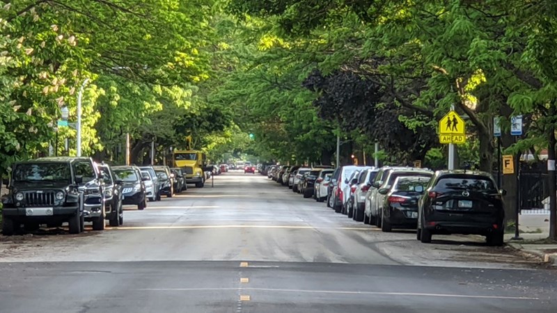 Cars parked on public neighborhood road during daytime