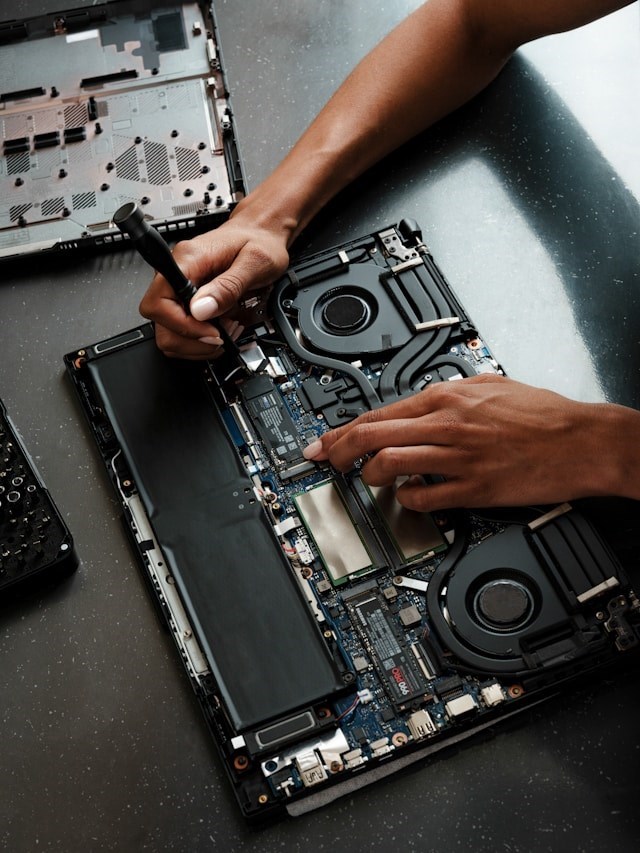 A laptop repairman fixing a laptop 