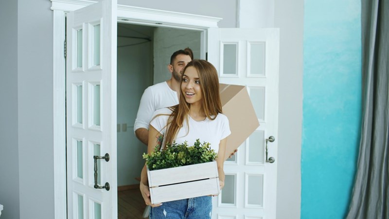 A man and a woman moving into a new place, model image