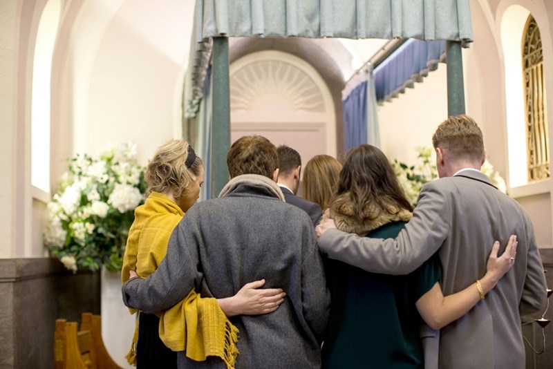 A family embracing on the day of a loved one's funeral