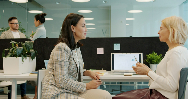 https://unsplash.com/photos/two-women-talking-at-a-desk-in-an-office-aoweP90-XwM