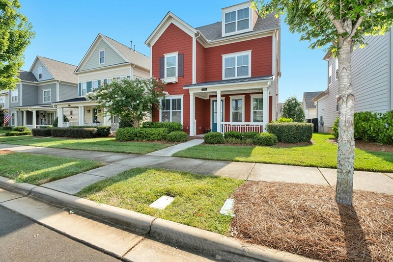 A representation of a homeowner standing outdoors in a residential area with trees and greenery in the background.