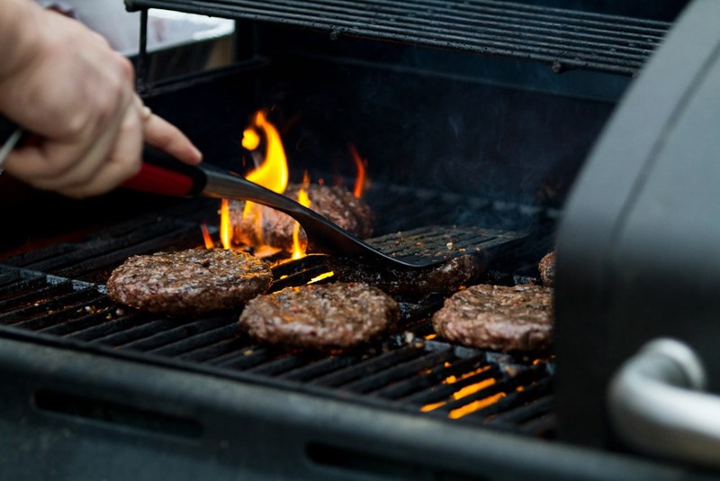 A person grilling meat, model image