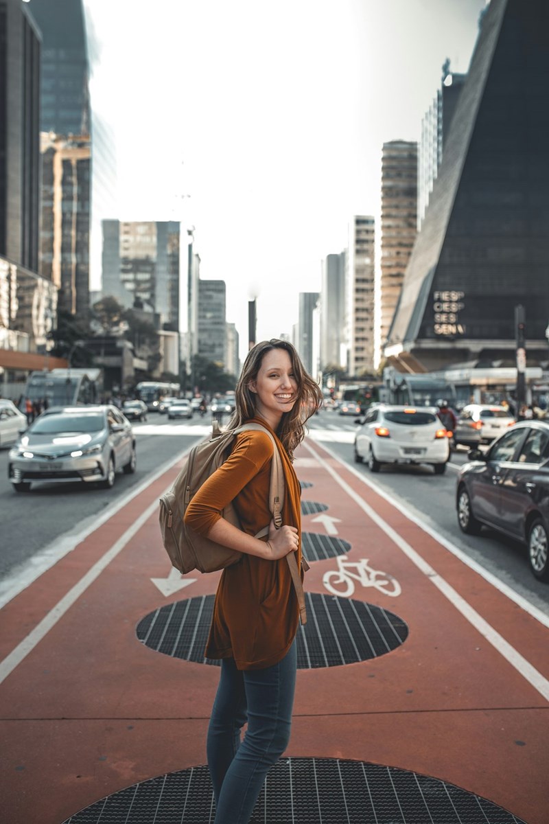 a woman standing in the middle of the road smiling