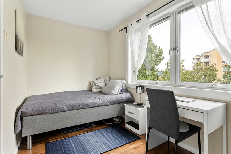 A furnished clean bedroom with bed and tv.