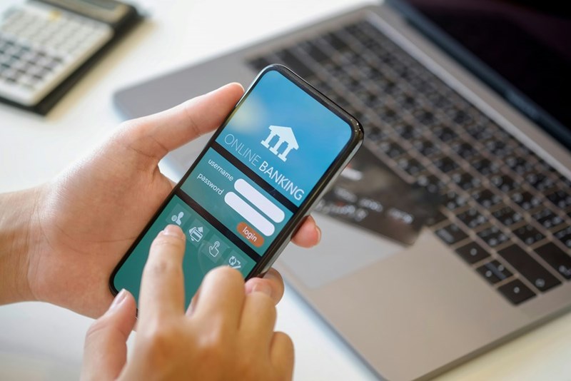 An illustration of a man using his smartphone to open an online banking app to transfer a moving van deposit refund to his girlfriend.