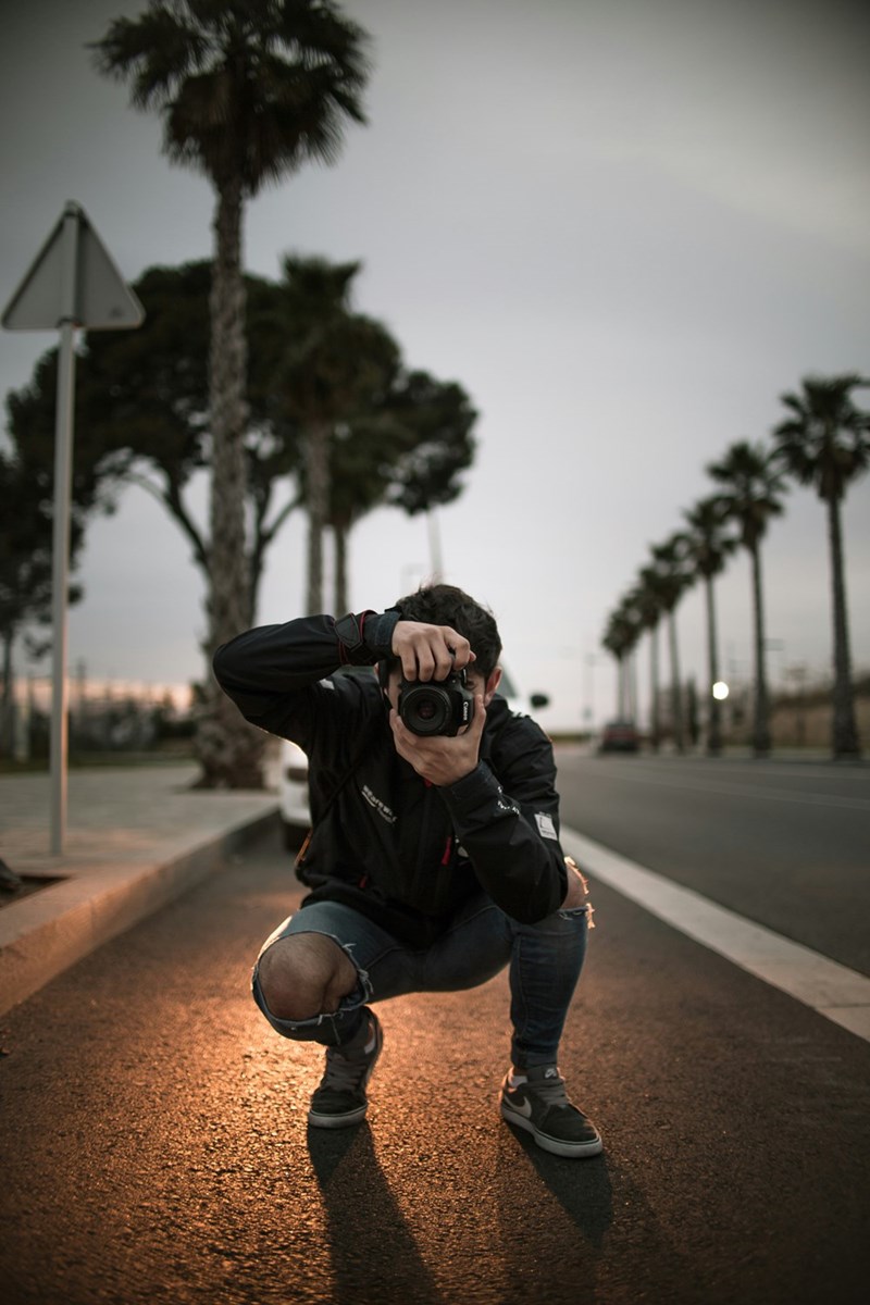 man taking a picture in the middle of the road