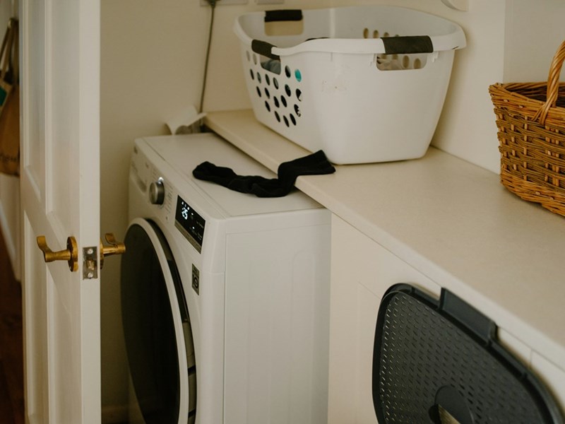 white washing machine with laundry basket
