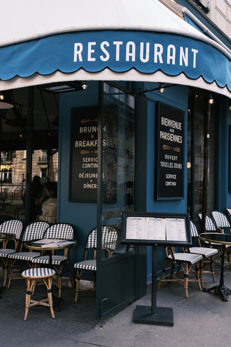 The entrance to a nice restaurant with a blue-and-white awning (stock).