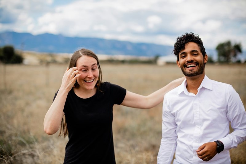 a man and a woman laughing in a field