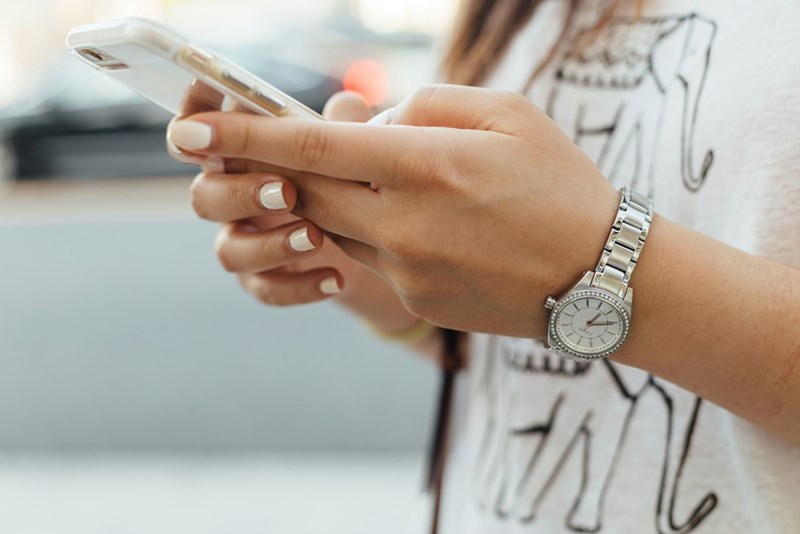 woman holding phone texting
