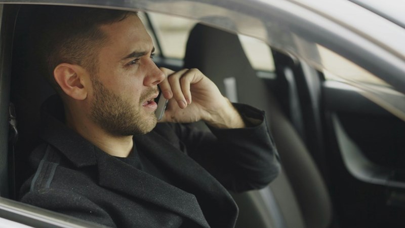 Man sitting in a car on a phone call.