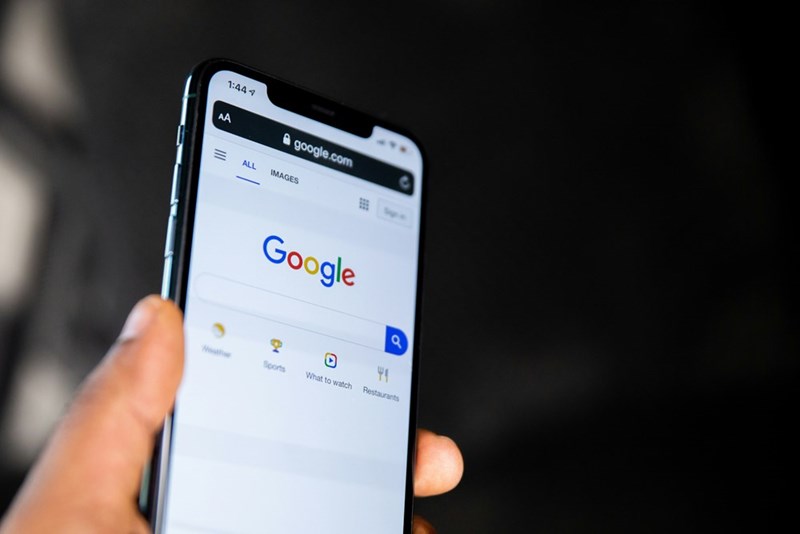 Person holding phone with a google search on the screen.