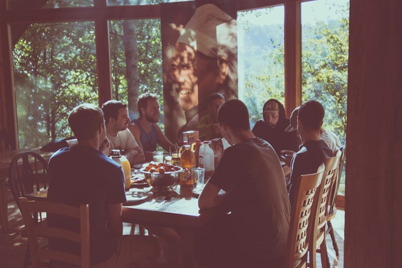a group of men eating in a restaurant