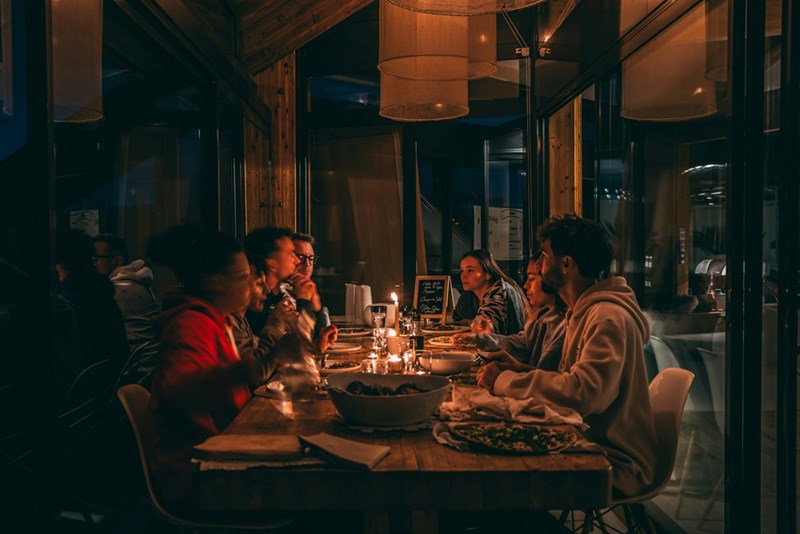 A representation of family members gathered around a restaurant table during a birthday celebration at a Thai restaurant.