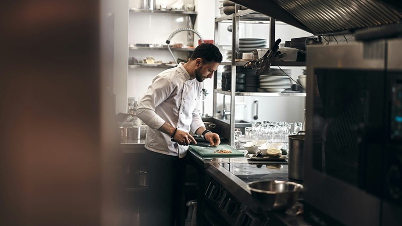A chef working in the kitchen of a restaurant, model image.