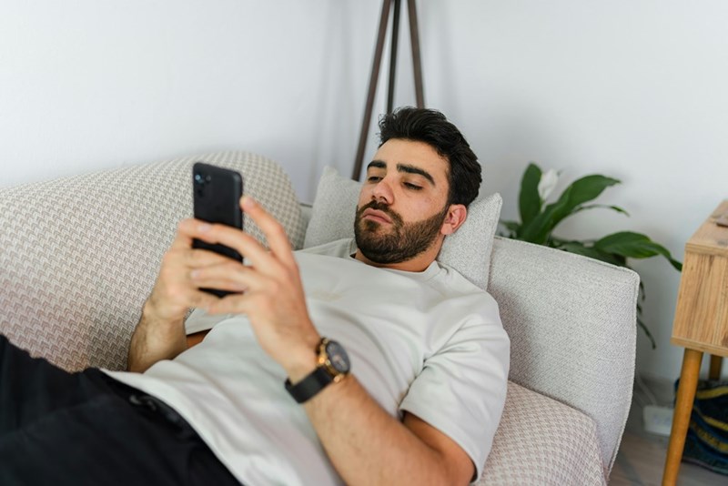 A man texting a potential romantic interest before meeting in person for the first time, represented by a model.