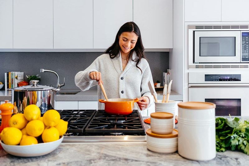 A representation of a woman preparing a homemade meal in a bright, modern kitchen.