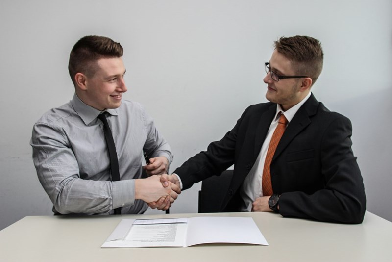 A representation of two business professionals shaking hands after a successful job meeting.